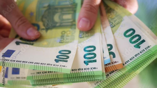 Hands hold different euro banknotes. State aid in times of crisis to compensate for inflation. Salary increase and basic social security. Inflation, purchasing power and social crisis.