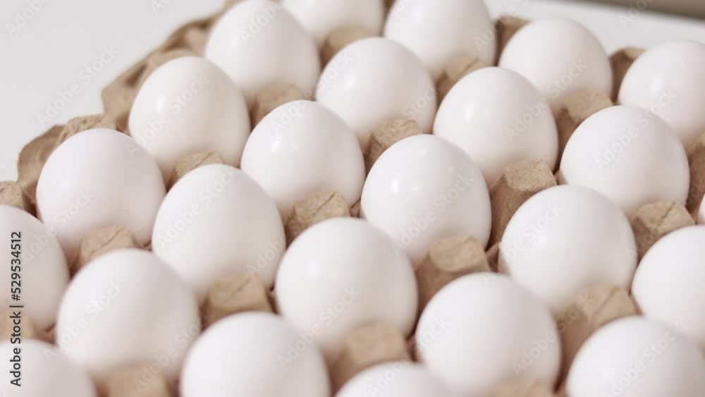White chicken eggs in a cardboard box. Fresh raw eggs in a paper egg container for store and shop. egg tray with eggs on white table background. Top view. preparation to easter holiday. White chicken eggs in a cardboard box. Fresh raw eggs in a paper egg container for store and shop. egg tray with eggs on white table background. Top view. preparation to easter holiday.