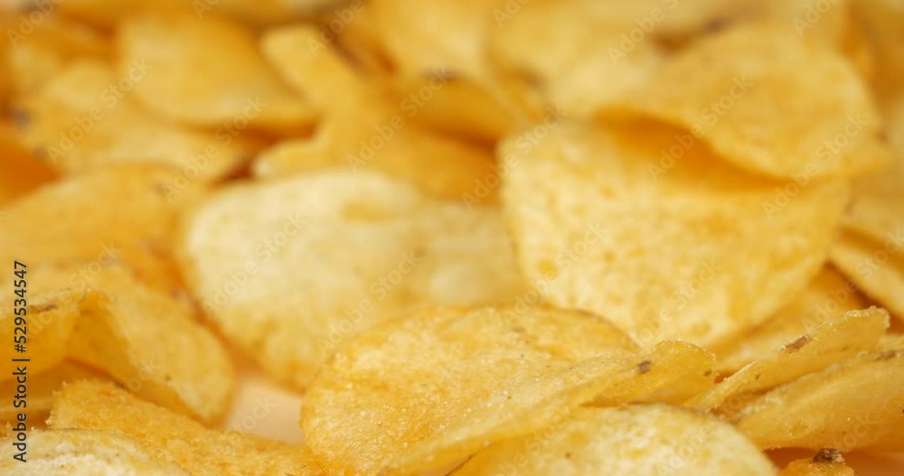 hand takes a golden potato chip closeup, salty snacks. High quality 4k footage hand takes a golden potato chip closeup, salty snacks. High quality 4k footage