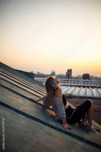 Photo shoot on the roof. Young woman posing in the roof, amazing view of city. People, lifestyle, relaxation concept. © maxbelchenko