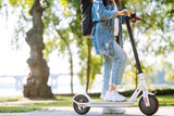 Legs of woman riding electric kick scooter on urban outdoor. Active life. Ecological transportation concept.