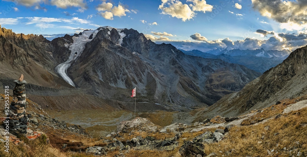 Great Panorama view of Mont Vélan from the cabane de valsorey with a Valais flag in the wind. Mountain tour in the Swiss mountains. High quality photo