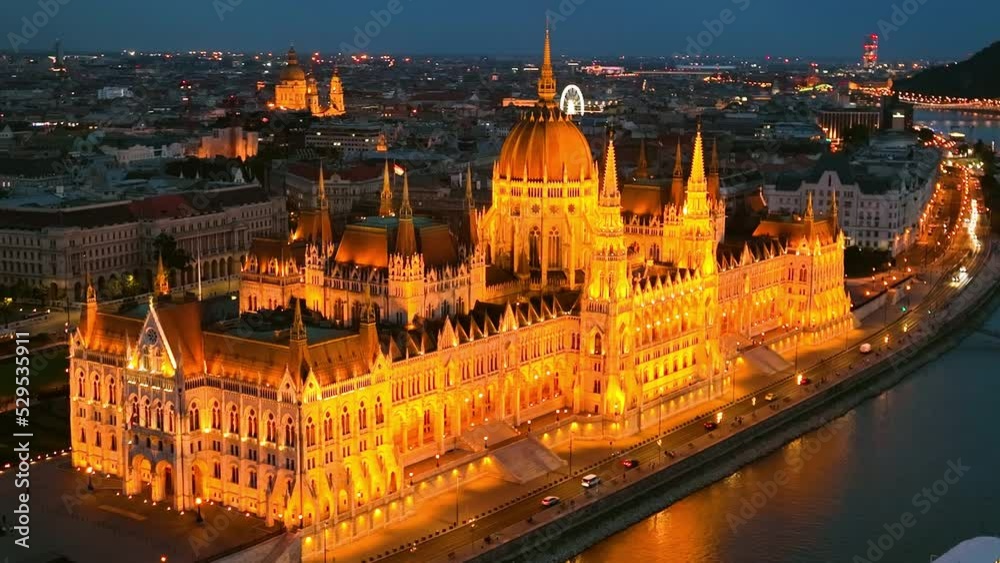 illuminated Hungarian Parliament Building with the Danube river, after sunset in Budapest, Hungary. 4K aerial drone view