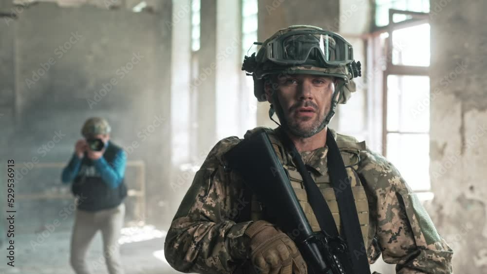 Portrait of professional fully equipped soldier with rifle at war ...