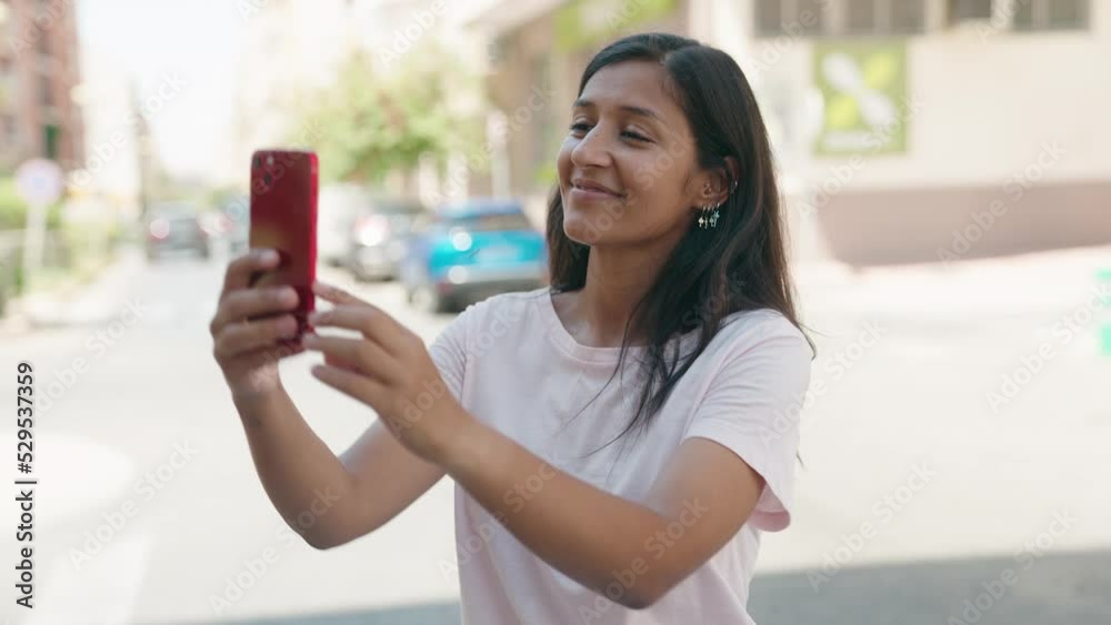 Young beautiful hispanic woman smiling confident making selfie by the smartphone at street Young beautiful hispanic woman smiling confident making selfie by the smartphone at street
