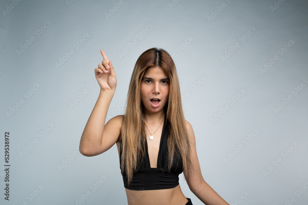 Surprised woman pointing finger up on the isolated white background.