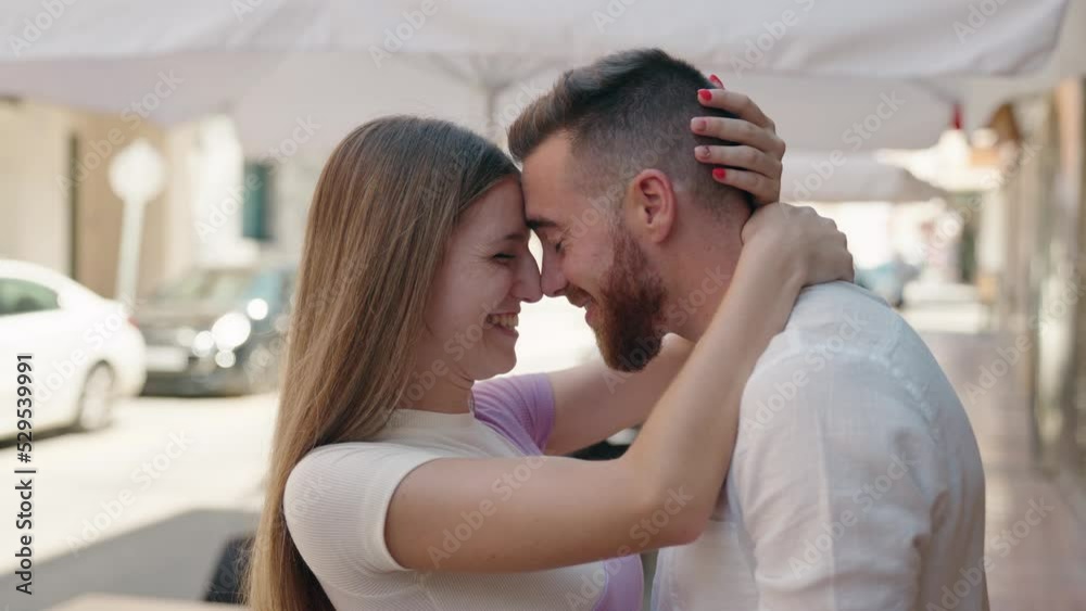 Man and woman couple hugging each other kissing at street Man and woman couple hugging each other kissing at street