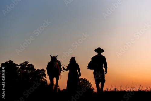 Horse and gaucho family on field at sunset silhouette photo