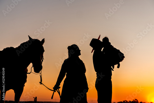 Foto Silhouette of horse and gaucho family at sunset