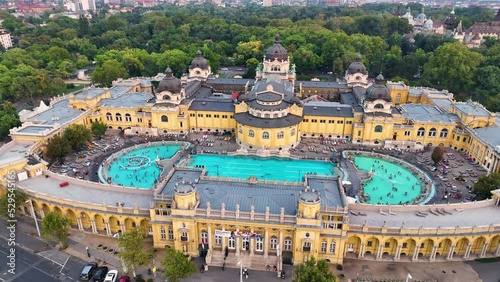 4K aerial drone view Szechenyi Bath. Drone flies around pool with many visitors. Budapest, Hungary