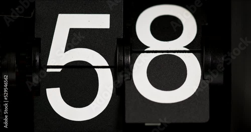 Flip clock Vintage countdown fifty-seven white numbers turning fifty-eight on black background. photo