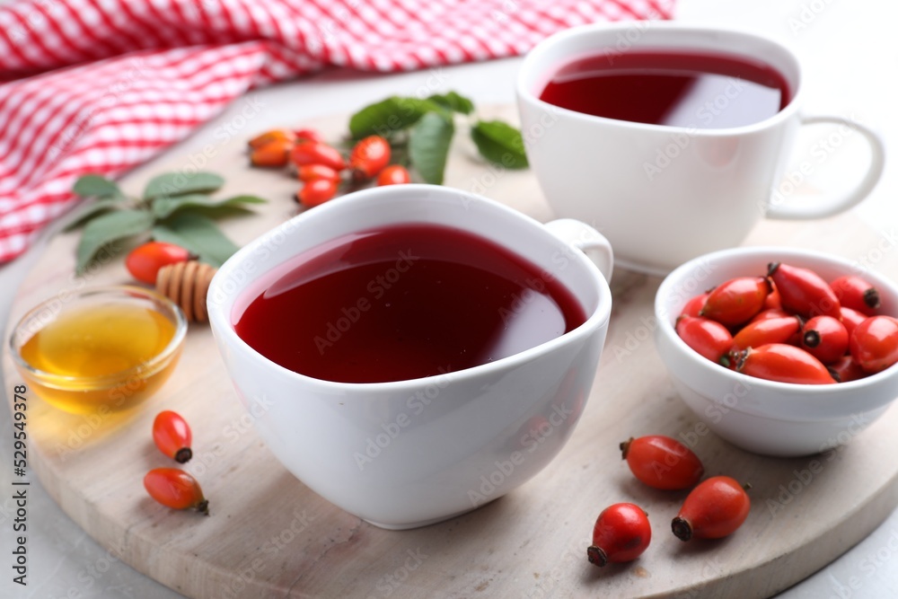 Fresh rose hip tea and berries on light table Fresh rose hip tea and berries on light table