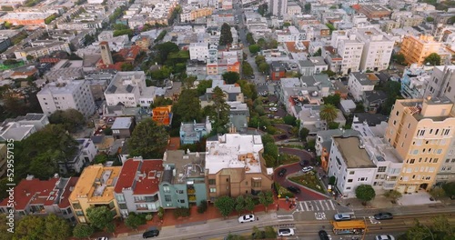 Bright modern dense architecture of San Francisco district. Aerial view on the famous Lombard Street with few cars slowly moving by its curves.