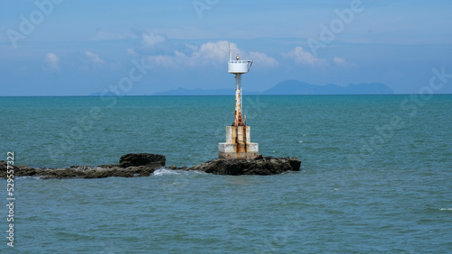 Classic vintage lighthouse or beacon in the ocean for the safety of fishing boats and fishery ship sailing in tropical sea.