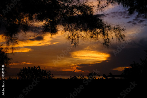 Beautiful sunset view on the beach. Colorful sea beach sunset with golden light reflected on the water surface and soft waves. Summer vacation and travel concept.