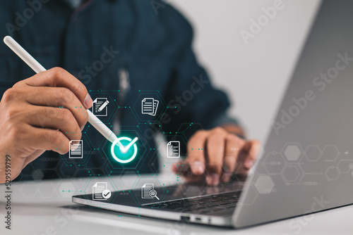 Businessman giving his approval to an electronic document while using a stylus pen and a digital tablet displaying a virtual document.