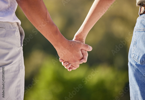 Hand, love and couple with a man and woman holding hands outside in care, trust and relationship. Closeup of a male and female walking outside together for romance and affection with trust outdoors