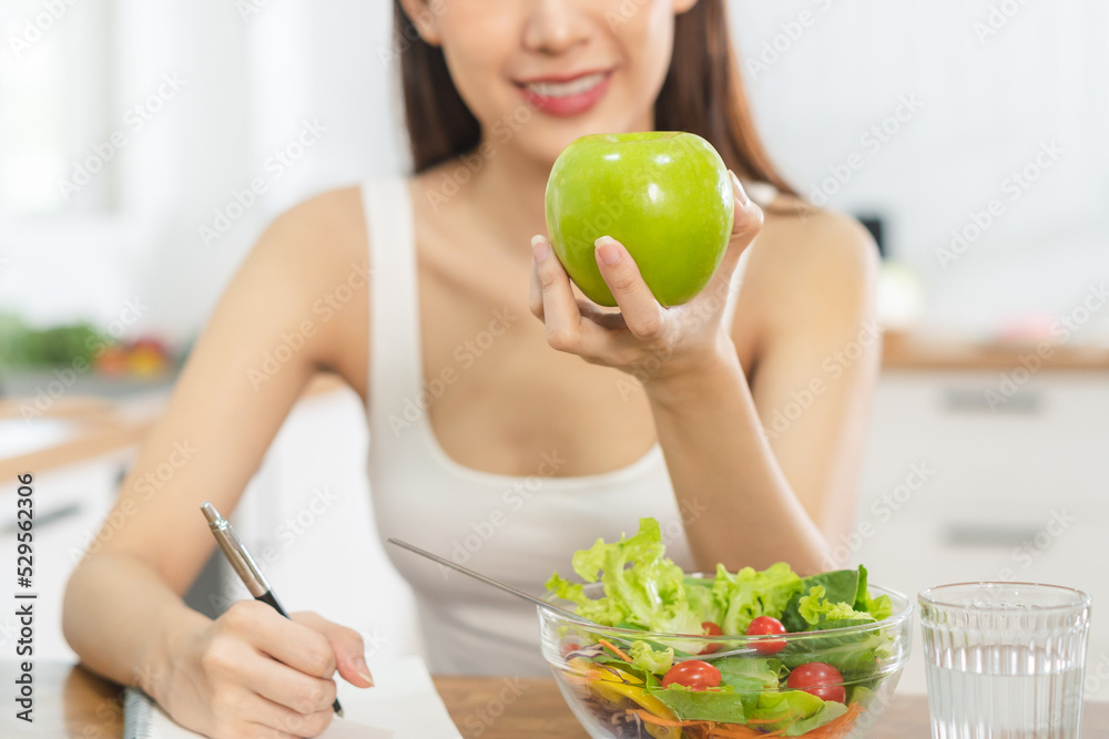 Diet, Dieting asian young woman, girl working diet plan right nutrition, hand holding green apple, vegetables salad is food for health not choose eat junk food. Nutritionist female, Weight loss person Diet, Dieting asian young woman, girl working diet plan right nutrition, hand holding green apple, vegetables salad is food for health not choose eat junk food. Nutritionist female, Weight loss person