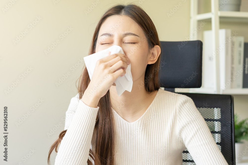 Sick, coronavirus covid-19. Attractive asian young woman, girl have a fever, flu and hand in use tissues paper sneezing nose, runny sitting on chair while working at home. Health care on virus person. Sick, coronavirus covid-19. Attractive asian young woman, girl have a fever, flu and hand in use tissues paper sneezing nose, runny sitting on chair while working at home. Health care on virus person.