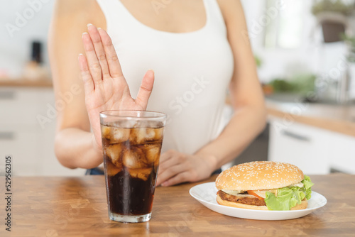Diet, Dieting hand of asian young woman deny, avoid hamburger, junk or fast food and sparkling water, soft drink, eat food for good healthy, health when hungry. Temptation of weight loss people. © KMPZZZ