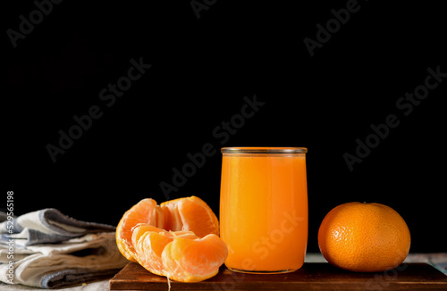 glass of fresh orange juice with fresh fruits on dark background, high Vitamin C, orange drink