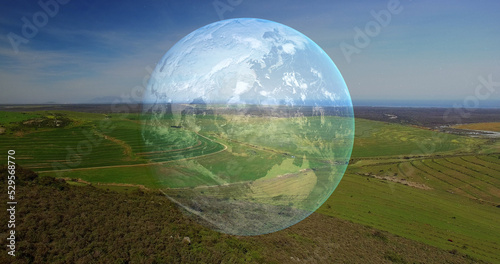 Image of spinning globe over landscape in mountains