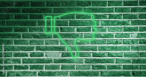 Image of glowing neon thumb down icon on brick wall photo