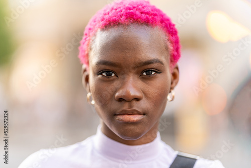 African woman with short pink hair outdoors