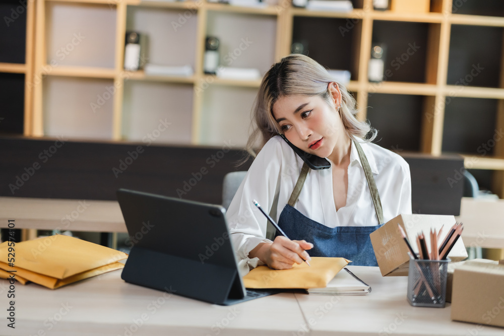 Asian woman sme entrepreneur startup e-business owner after checking order from online shopping delivery to customer success shopping small business. Asian woman sme entrepreneur startup e-business owner after checking order from online shopping delivery to customer success shopping small business.