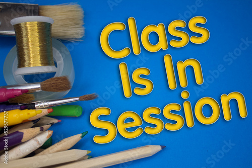 Overhead shot of school supplies with Class Is In Session text. Brushes, pencils, artistic tools. Art And Craft Work Tools.