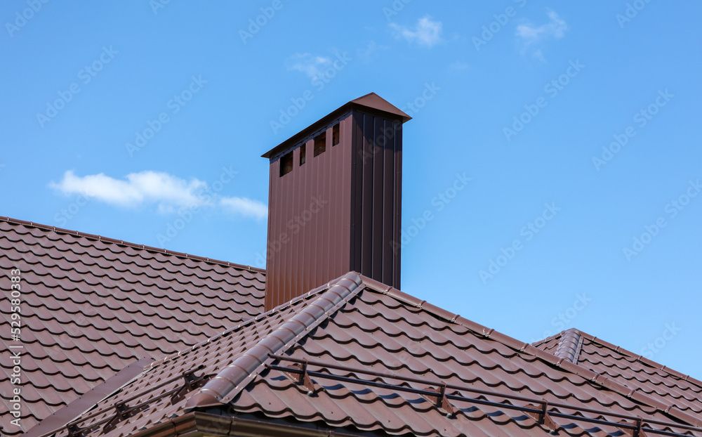 Brown metal pipe on the roof of the house Brown metal pipe on the roof of the house