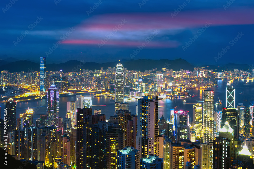 Hong Kong aerial view of Victoria Harbor. Business building from viewpoint of the Victoria Peak at dusk. Landscape of Hong Kong city with modern high building in business district area.