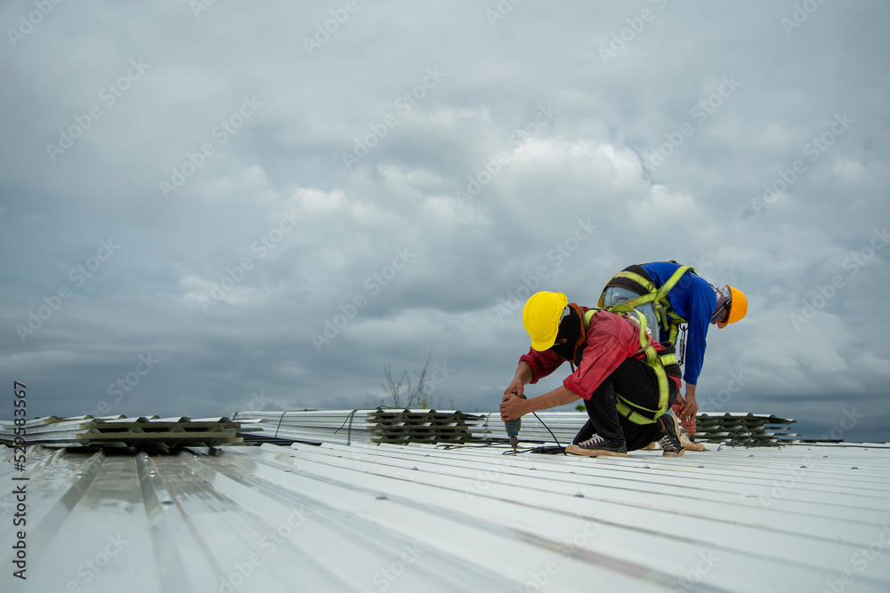 Asian construction worker holding metal sheet installation tool to build industrial factory roof - obrazy, fototapety, plakaty 