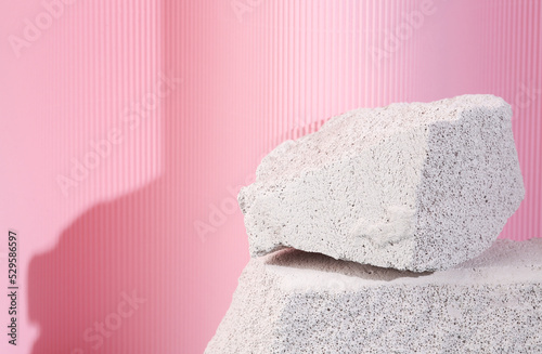 Minimalist showcase. Scene from natural stack of stone on pink background. Podium for products