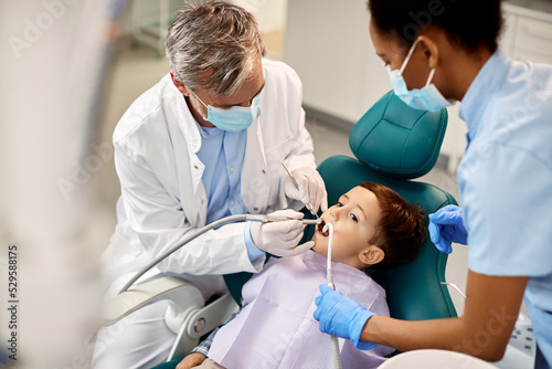 Small kid during dental procedure at pediatric dentistry clinic.