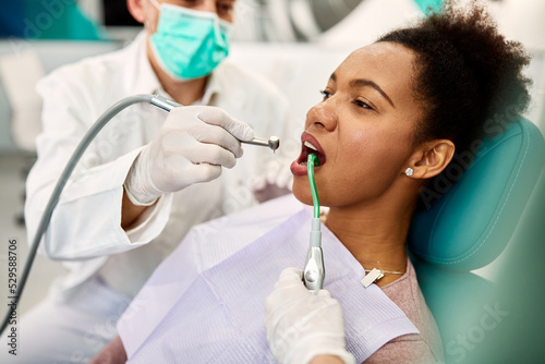 Mid adult black woman during dental procedure at dentist's office.