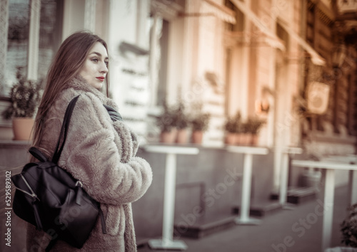 Fashion woman in a luxurious fur coat walking in city