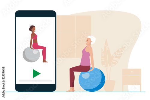 Elderly woman takes online lessons of Exercises with fitball. Senior Woman watches sports lessons on your phone. Women doing training. Healthy lifestyle in old age. Exercises for elderly.