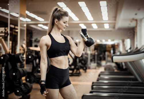 Sexy young fit woman with a perfect body dressed in sportswear trains with a kettlebell in a modern gym. Healthy lifestyle © splitov27
