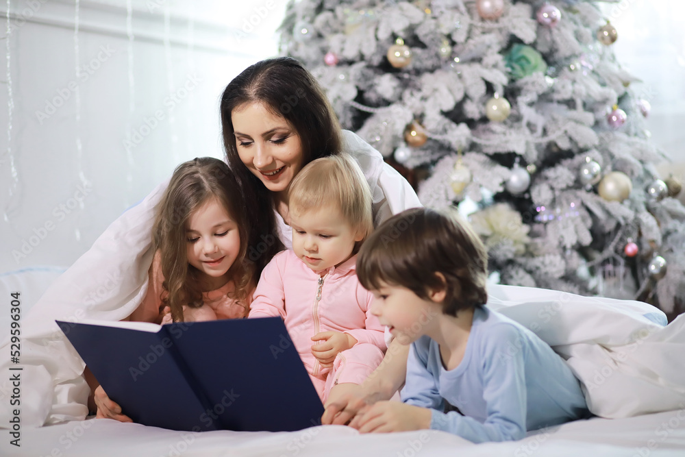 A family with children having fun on the bed under the covers during the Christmas holidays. A family with children having fun on the bed under the covers during the Christmas holidays.