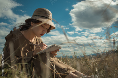 young lady sketching in the field in sunny weather