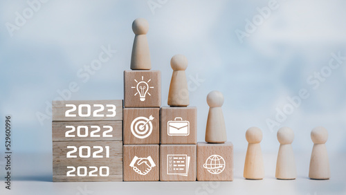 Hand holding number 2023 on square wood and icon on white background, Money spending planning, plant growing up on coins and investment budget, Save money for prepare in the future, new year