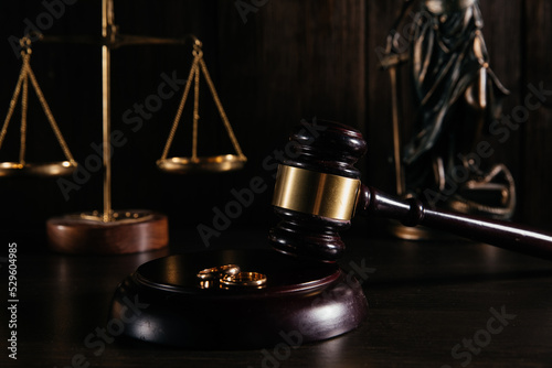 Gold wedding rings on wooden mallet at table in courtroom