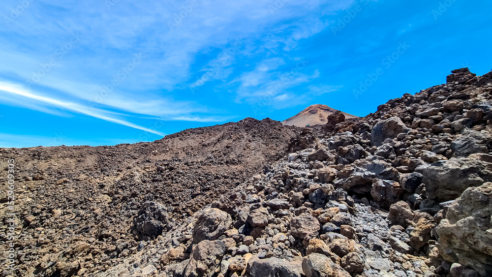 Hiking trail over volcanic desert terrain leading to summit of volcano Pico del Teide from Pico Viejo, Mount Teide National Park, Tenerife, Canary Islands, Spain, Europe. Solidified lava, ash, pumice
