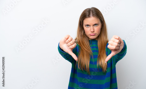 Young caucasian woman isolated on white background showing thumb down with two hands