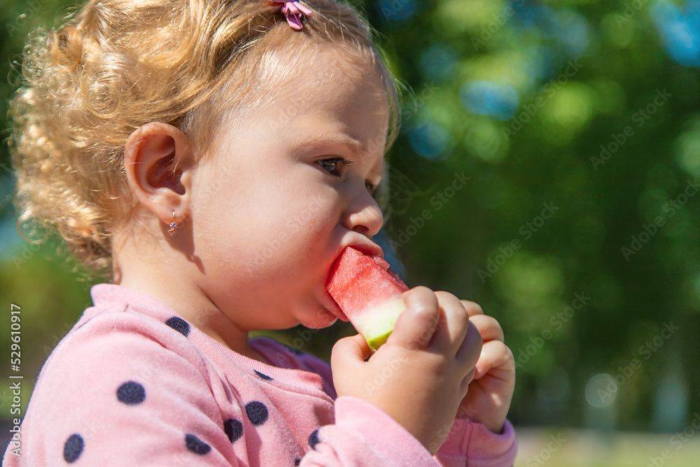 The child eats watermelon in summer. Selective focus. The child eats watermelon in summer. Selective focus.