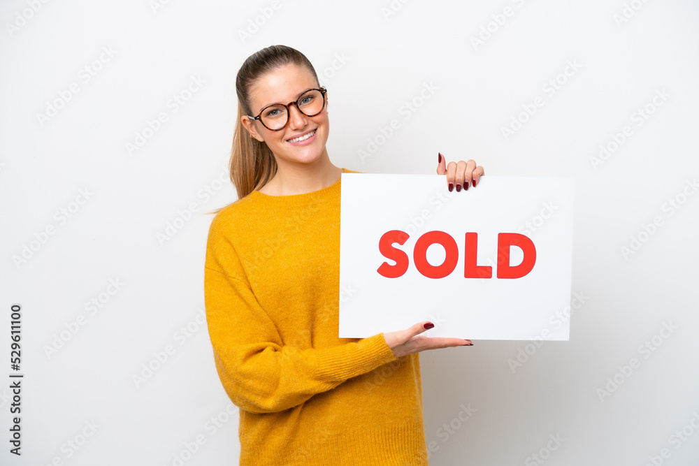 Young caucasian woman isolated on white background holding a placard with text SOLD with happy expression Young caucasian woman isolated on white background holding a placard with text SOLD with happy expression