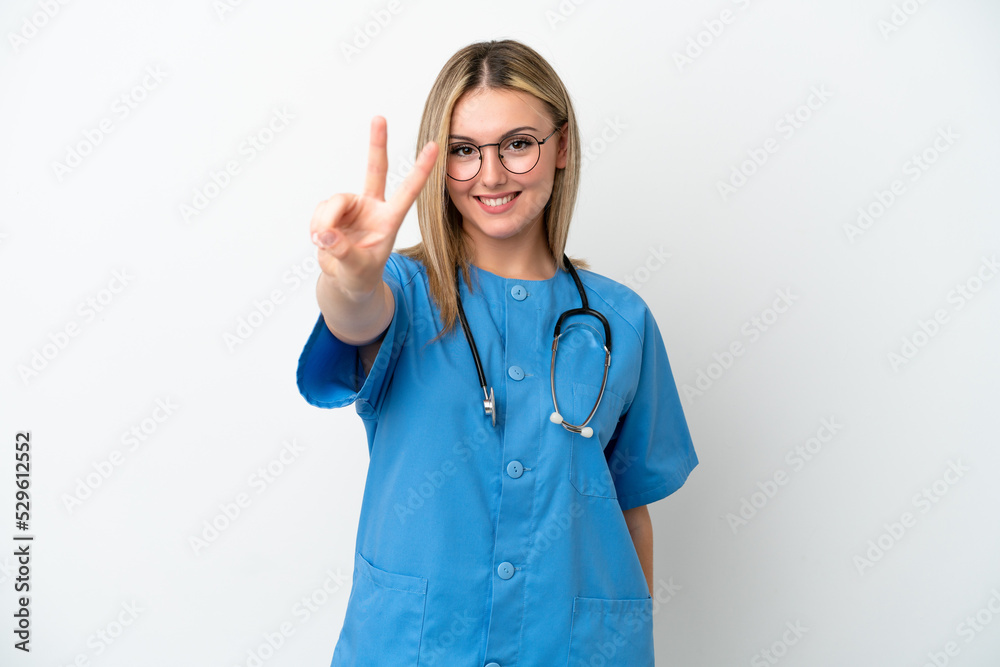 Young surgeon doctor woman isolated on white background smiling and showing victory sign Young surgeon doctor woman isolated on white background smiling and showing victory sign