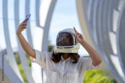 Asian woman dressed as an astronaut taking a photo