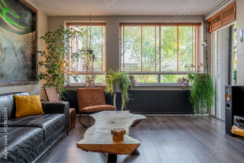 Interior with slatted window and a lot of plants and yellow design